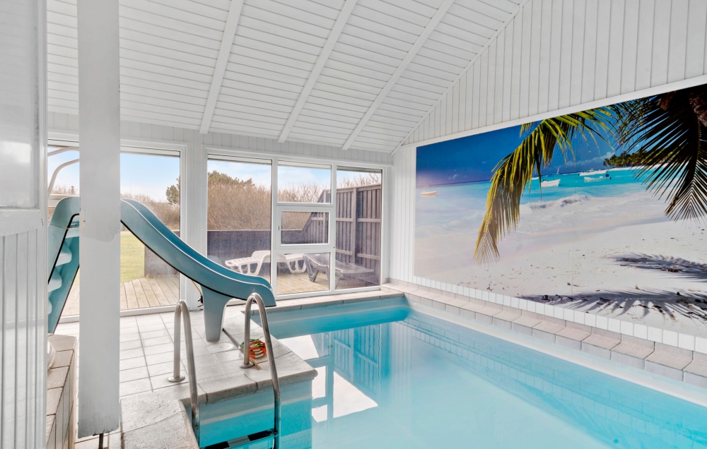 Sommarstuga 105 är inredd med en smakfull poolavdelning som har vattenrutschbana, ett stort inbyggt spapad och bastu
