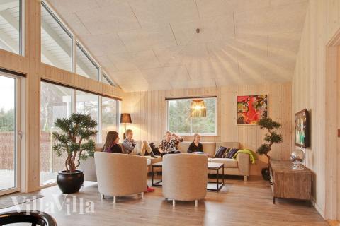 Allrummet är inrättat med komfortabel soffgrupp, kakelugn och tv