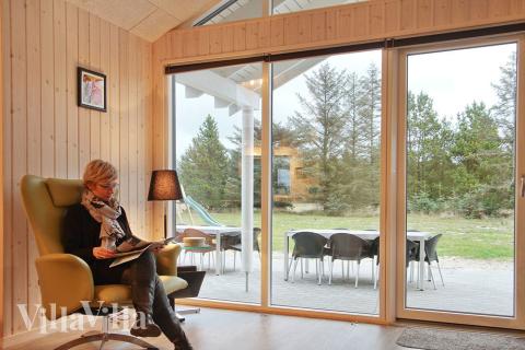 Allrummet, som har utsikt över tomten, är smakfullt inrett med sköna möbler, kakelugn och plattskärms-tv