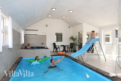 Det är bara att hoppa i – poolen på 21 m2 har undervattensbelysning, motströms-anläggning och rutschbana