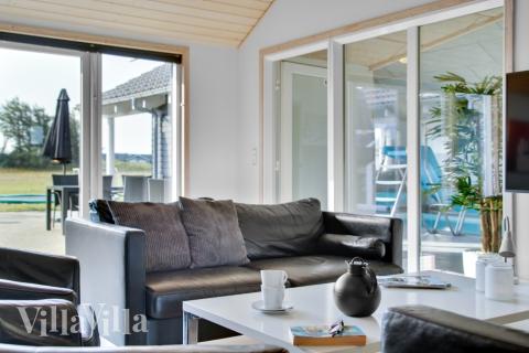 I soffhörnan i lyxstuga 194 i Nordjylland kan ni spela brädspel eller titta på film tillsammans.