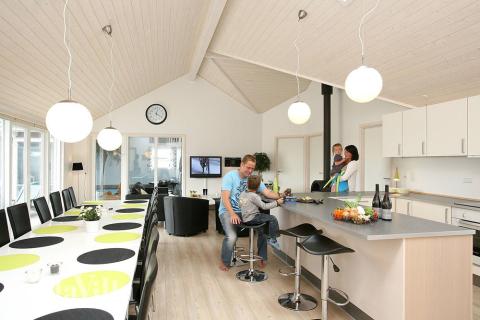 Husets mittpunkt är inrättat med ljust och öppet kök, matplats, soffgrupp och kakelugn