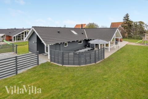 Den praktfulla poolstugan nr 264 med plats för 14 personer ligger i Sydjylland