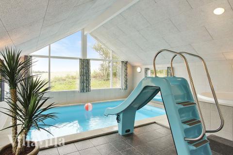 Badglada gäster kan utnyttja husets pool med vattenrutschbana och motströmsanläggning