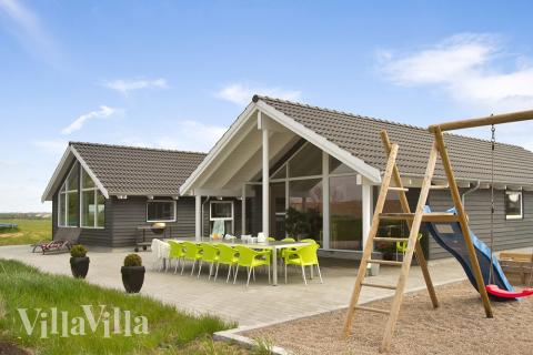 På husets tomt finns gungor och sandlåda. Medans barnen leker kan de vuxna njuta av solen på husets stora terrass