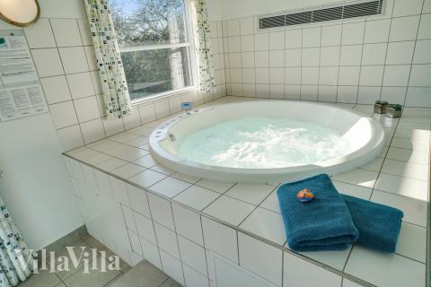 Njut av spabadets värme i lyxstuga nr 241 i Sydjylland