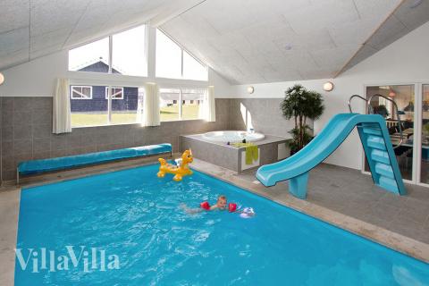 Både stora och små vattendjur kan roa sig i timvis i husets 19 m2 pool med romersk trappa och vattenrutschbana