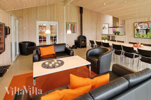 Allrummet, som har utsikt över tomten, är smakfullt inrett med sköna möbler, kakelugn och plattskärms-tv