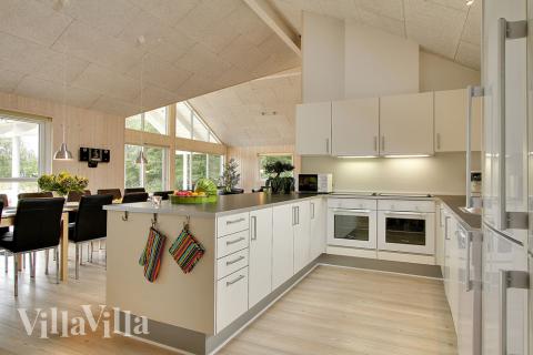 Köket är väl utrustat och ligger i öppen förbindelse med matsalsplats och soffgrupp