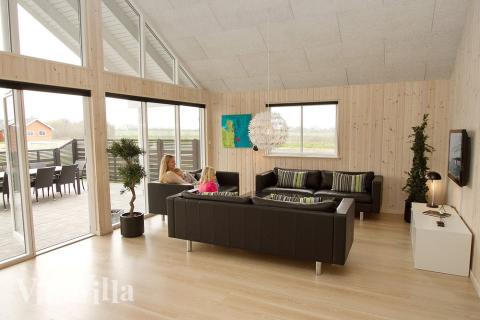 Vardagsrummet ligger i öppen förbindelse med köket-allrummet – och här kan man tända upp i kakelugnen och slänga sig i soffan