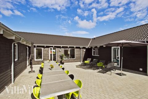 På den stora terrassen kan sommardagarna njutas i sköna trädgårdsmöbler, och barnen har en stor gräsplan och sandlåda för utomhuslekar