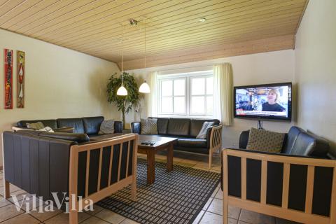 En av husets favoritplatser brukar vara allrummet med de lädermöblerna framför den sprakande kakelugnen