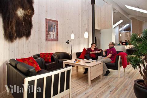 Vid den stora soffgruppen finns plattskärms-tv, dvd, komfortabla möbler och kakelugn som kan ge lite extra trevnad vid en kylig afton