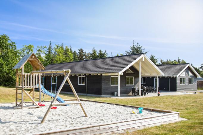 Detta praktfulla sommarhus är uppfört tätt inpå stranden och den populära semesterbyn Blåvand
