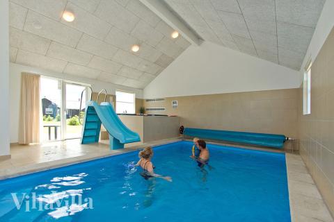 Både små och stora vattenälskare kan vältra sig i timmar i husets pool med motströmsanläggning och vattenrutschbana