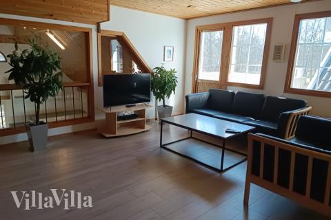 Vardagsrummet på 1:a plan är inrättat med 2 soffgrupper, utgång till altanen och insyn till poolavdelningen