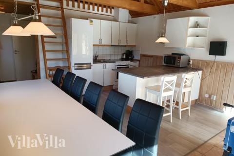 Allrummet ligger i öppen förbindelse med köket och har matsalsplatser för 12 och kakelugn