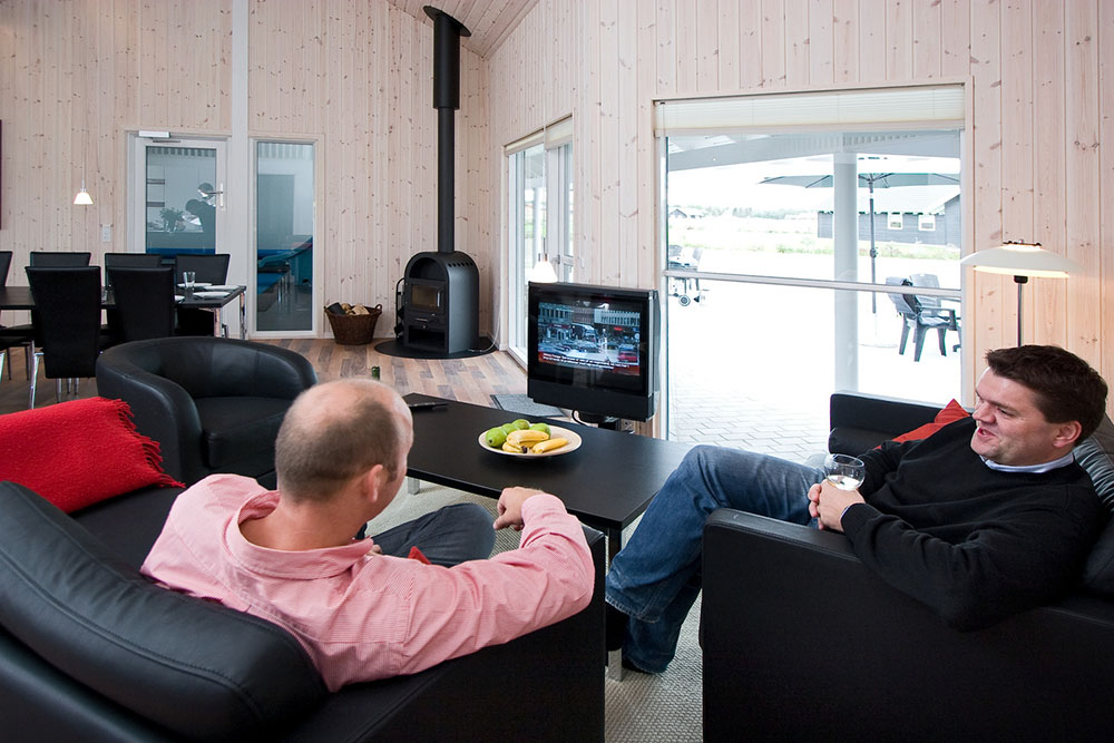 Komfortabla möbler, plattskärms-tv och kakelugn skapar en mysig och avslappnad miljö i huset
