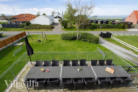 På husets stora terrass kan man njuta av sommarvädret medans barnen leker i trädgården 