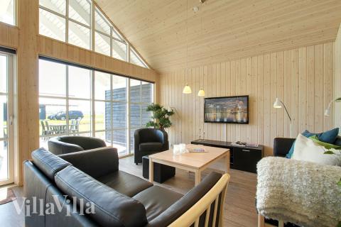 Stugan är mysigt möblerad med soffgrupp och kakelugn, som kan ge lite extra trevnad och värme under en kylig dag