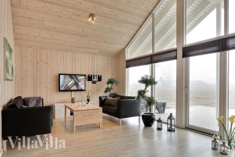 Komfortabla möbler, plattskärms-tv och kakelugn skapar en mysig och avslappnad miljö i huset