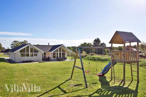 På husets tomt finns gungor och sandlåda. Medans barnen leker kan de vuxna njuta av solen på husets stora terrass