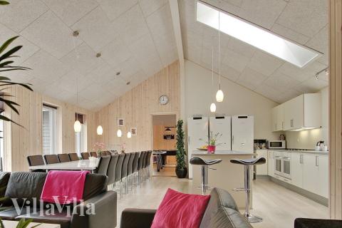 Husets mittpunkt är inrättat med ljust och öppet kök, matplats, soffgrupp och kakelugn