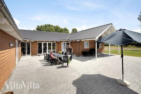 Husets stora terrass, som är delvis takbelagd, har sköna trädgårdsmöbler och 2 stengrillar