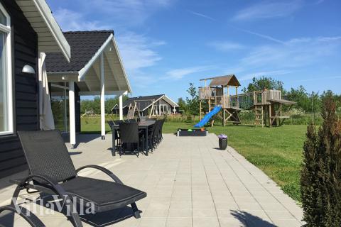 Den delvis täckta terrassen är perfekt för varma sommardagar eller långa grillaftnar, och för de minsta gästerna finns där sandlåda och gunga i trädgården