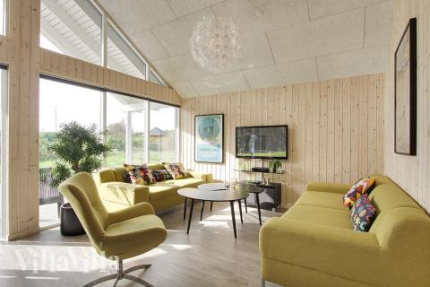 Allrummet, som har utsikt över tomten, är smakfullt inrett med sköna möbler, kakelugn och plattskärms-tv