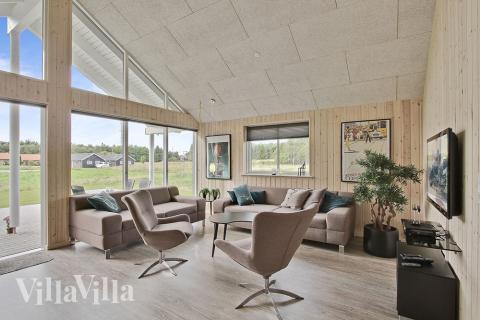 Allrummet är inrättat med komfortabel soffgrupp, kakelugn och tv