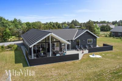Detta exklusiva lyxsommarhus är uppfört i det eftertraktade sommarhusområdet nära stranden och den charmerande byn Blåvand