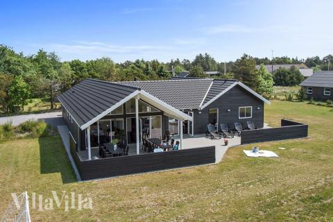 Detta exklusiva lyxsommarhus är uppfört i det eftertraktade sommarhusområdet nära stranden och den charmerande byn Blåvand