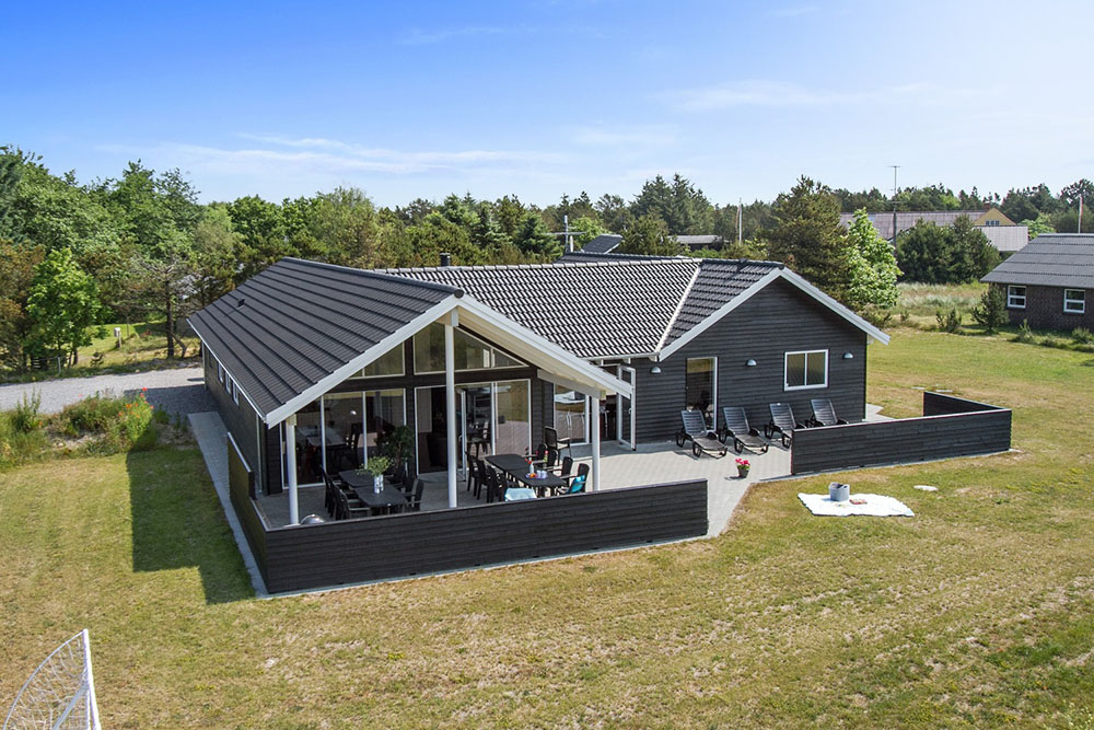 Detta exklusiva lyxsommarhus är uppfört i det eftertraktade sommarhusområdet nära stranden och den charmerande byn Blåvand