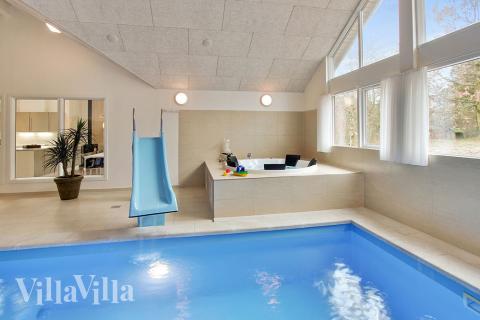 Både små och stora vattenälskare kan vältra sig i timmar i husets stora pool med motströmsanläggning och vattenrutschbana