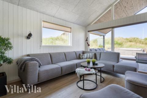 I soffhörnan i lyxstuga 348 i Vestjylland kan ni spela brädspel eller titta på film tillsammans.