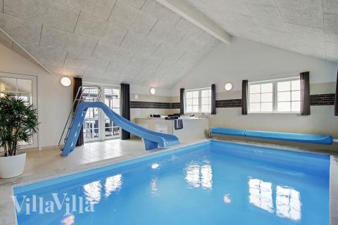 Sommarstuga 386 är inredd med en smakfull poolavdelning som har vattenrutschbana, ett stort inbyggt spapad och bastu