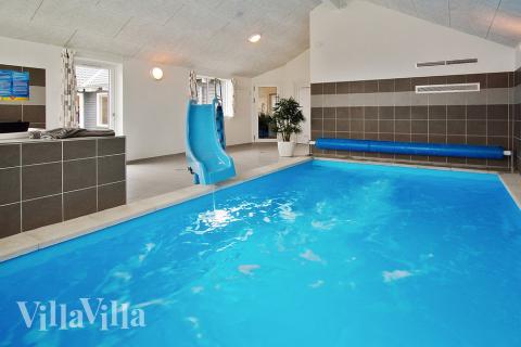 Sommarstuga 703 är inredd med en smakfull poolavdelning som har vattenrutschbana, ett stort inbyggt spapad och bastu