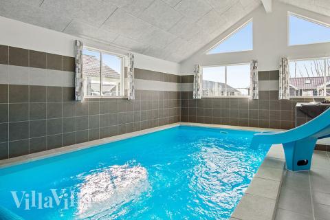 Sommarstuga 705 är inredd med en smakfull poolavdelning som har vattenrutschbana, ett stort inbyggt spapad och bastu