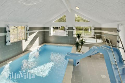 Sommarstuga 406 är inredd med en smakfull poolavdelning som har vattenrutschbana, ett stort inbyggt spapad och bastu