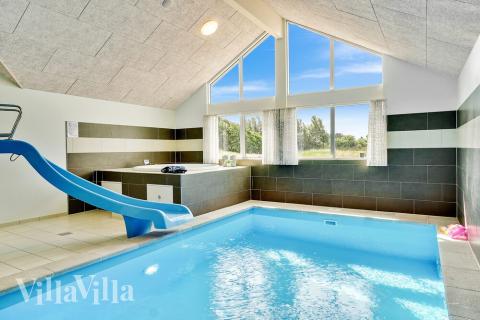 Sommarstuga 416 är inredd med en smakfull poolavdelning som har vattenrutschbana, ett stort inbyggt spapad och bastu