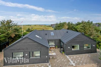 Den praktfulla poolstugan nr 411 med plats för 14 personer ligger i Nordjylland