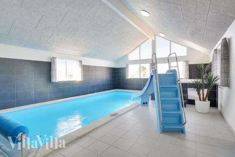 Sommarstuga 446 är inredd med en smakfull poolavdelning som har vattenrutschbana, ett stort inbyggt spapad och bastu