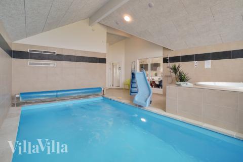 Sommarstuga 437 är inredd med en smakfull poolavdelning som har vattenrutschbana, ett stort inbyggt spapad och bastu