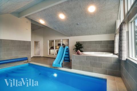 Sommarstuga 473 är inredd med en smakfull poolavdelning som har vattenrutschbana, ett stort inbyggt spapad och bastu