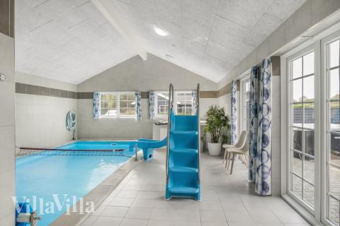 Sommarstuga 500 är inredd med en smakfull poolavdelning som har vattenrutschbana, ett stort inbyggt spapad och bastu