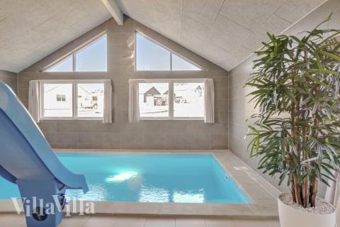 Sommarstuga 504 är inredd med en smakfull poolavdelning som har vattenrutschbana, ett stort inbyggt spapad och bastu