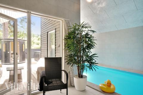 Sommarstuga 519 är inredd med en smakfull poolavdelning som har vattenrutschbana, ett stort inbyggt spapad och bastu