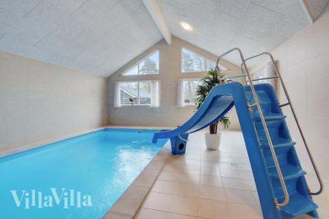 Sommarstuga 513 är inredd med en smakfull poolavdelning som har vattenrutschbana, ett stort inbyggt spapad och bastu