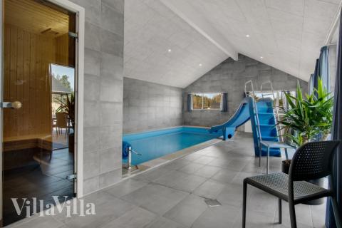 Sommarstuga 554 är inredd med en smakfull poolavdelning som har vattenrutschbana, ett stort inbyggt spapad och bastu